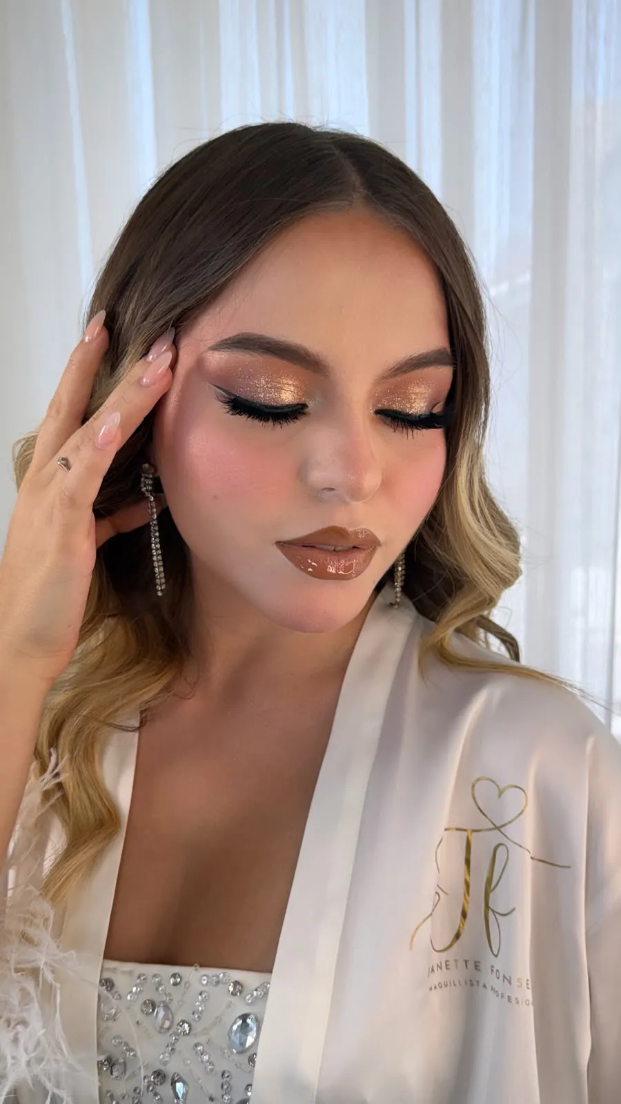 Maquillaje con técnica aerógrafo, glitter dorado y piel efecto filtro, clienta con bata Janette Fonseca